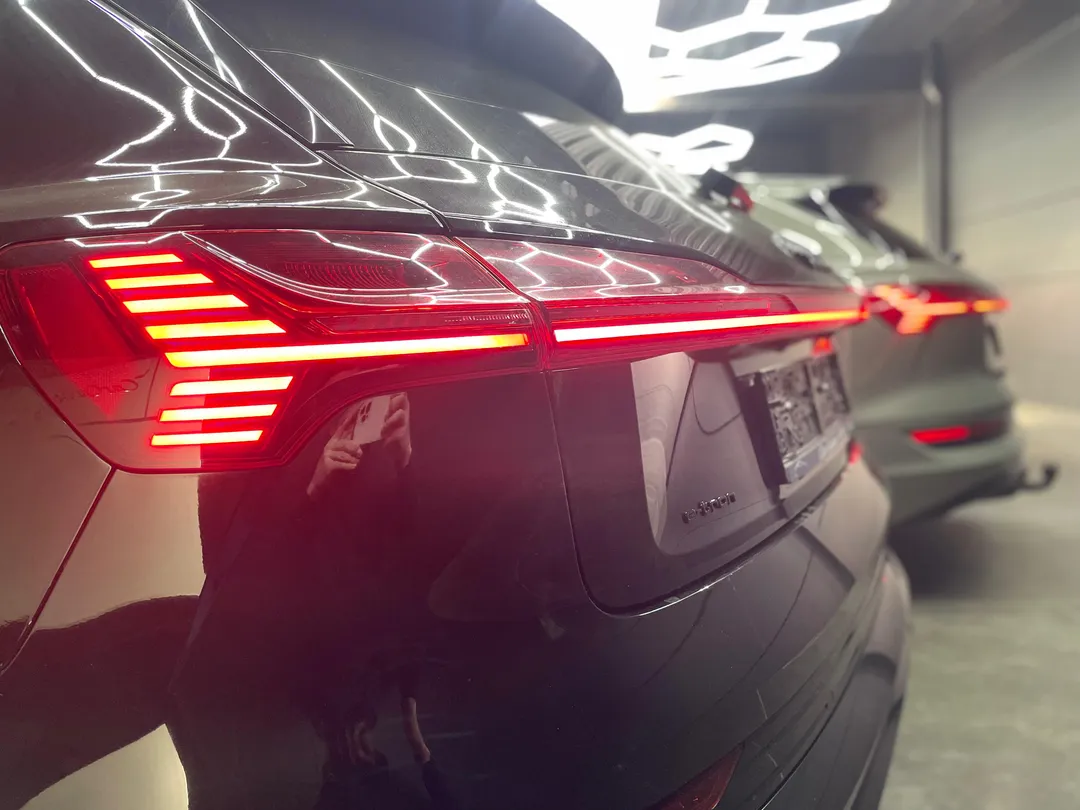 Achterzijde van een zwarte Audi e-tron premium tweedehands wagen in de showroom van Car Center STV in Menen.